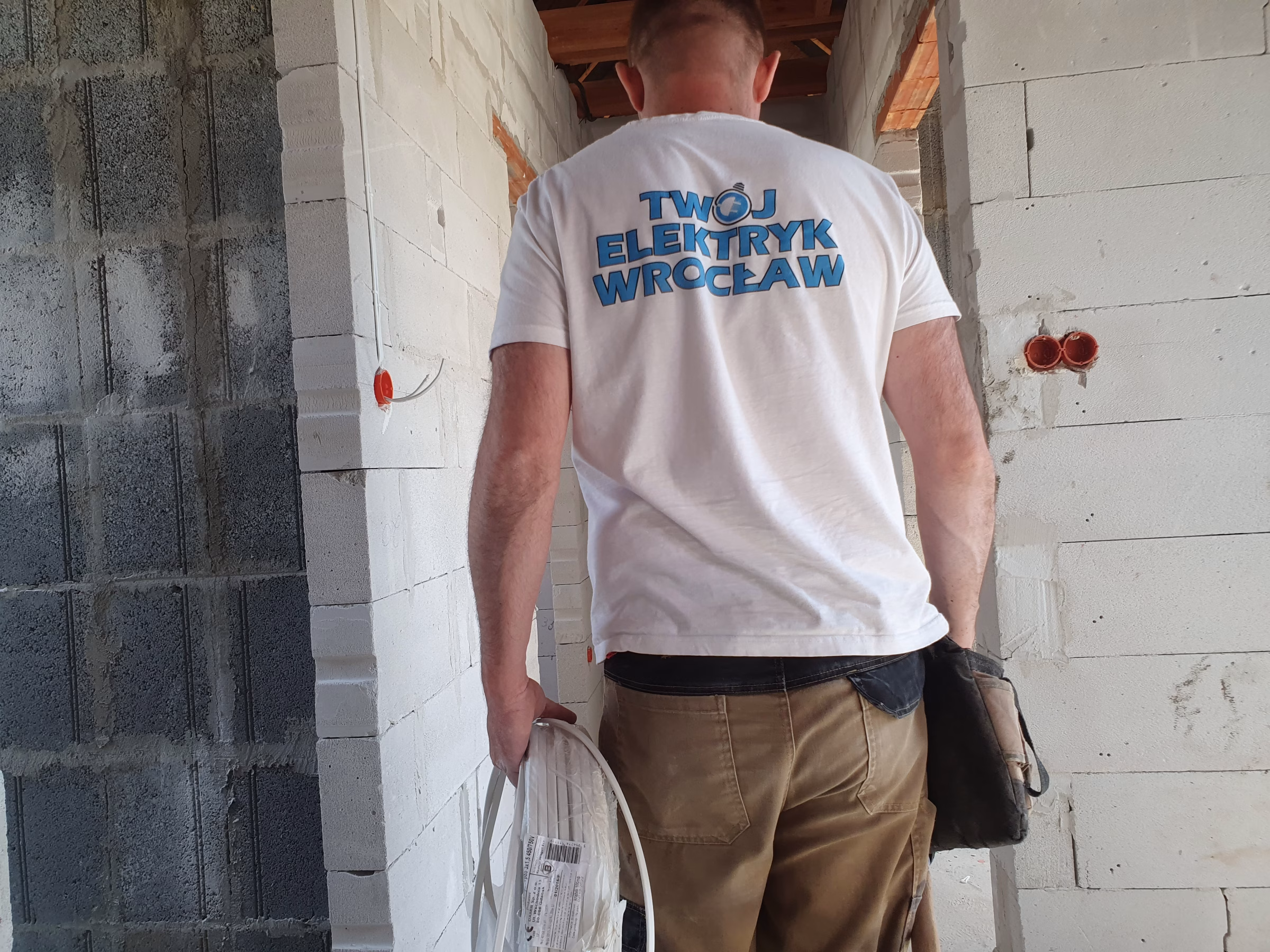 elektryk z Wrocławia idzie układać instalaję elektryczną